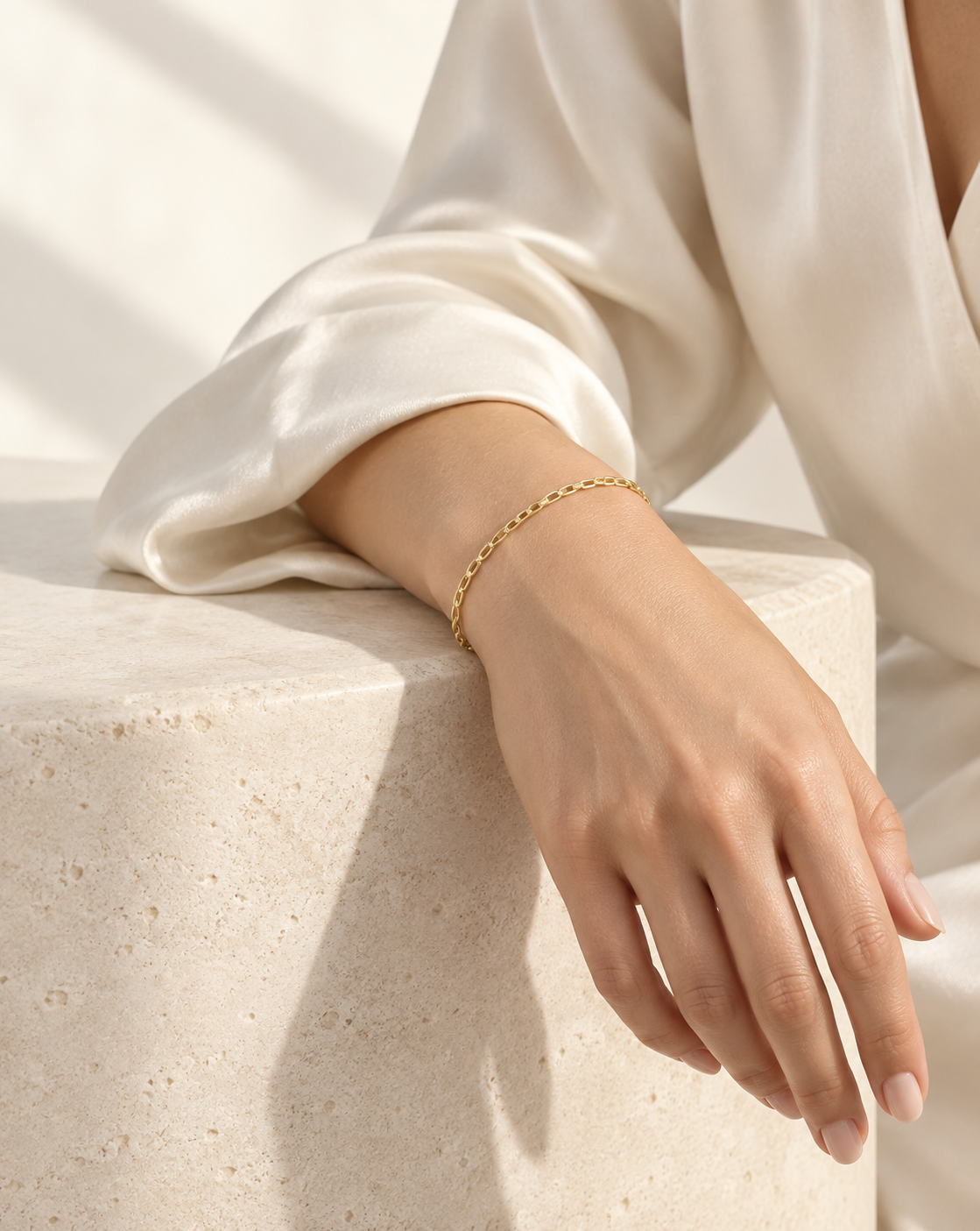 A model wearing a delicate gold chain bracelet